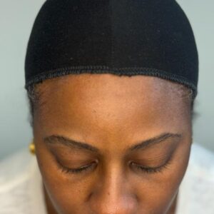 Close up-front image of black bamboo wig cap liner on head of black woman.