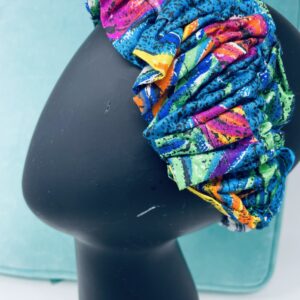 Close up view of a multicolor fabric headband on a mannequin head.