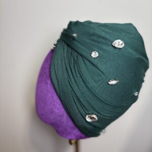 Turban with large stones over a mannequin head.
